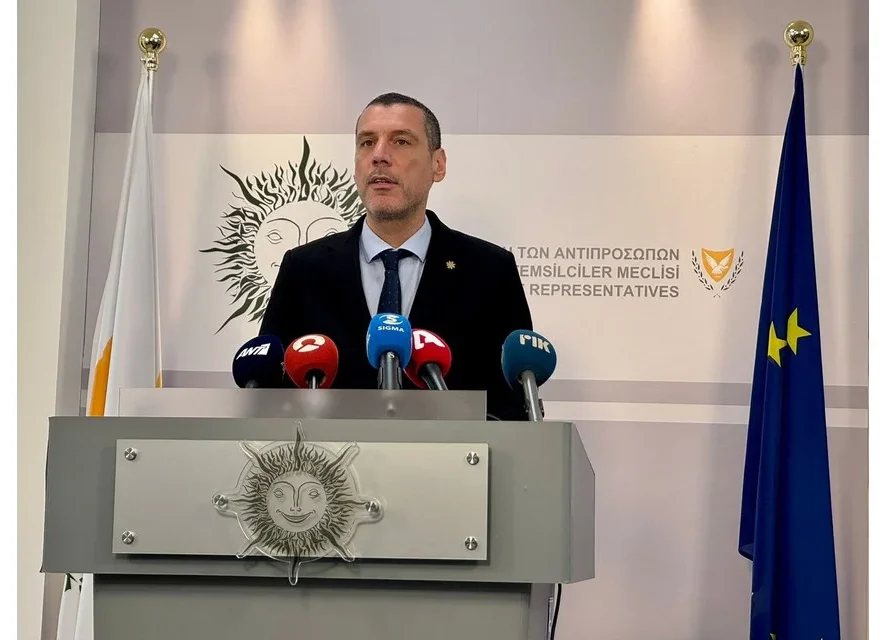 Ο Υπουργός Υγείας να μιλά στα μέλη της Κοινοβουλευτικής Επιτροπής Υγείας με φόντο το κτίριο της Βουλής.