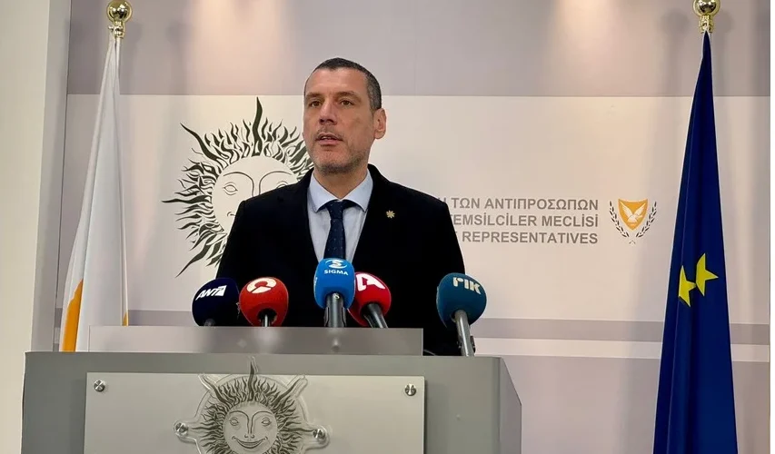 Ο Υπουργός Υγείας να μιλά στα μέλη της Κοινοβουλευτικής Επιτροπής Υγείας με φόντο το κτίριο της Βουλής.