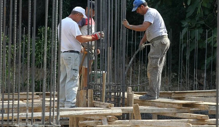 Εργαζόμενοι σε εξωτερικό χώρο κατά τη διάρκεια καύσωνα με μέτρα προστασίας από τις υψηλές θερμοκρασίες.